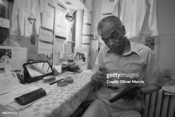 American tap dancer and actor Charles 'Honi' Coles tunes his tap shoes prior to a performance at the St. James Theater, New York, New York, 1984.