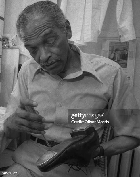American tap dancer and actor Charles 'Honi' Coles tunes his tap shoes prior to a performance at the St. James Theater, New York, New York, 1984.