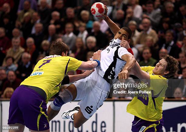 Daniel Narcisse of Kiel shoots at goal against Rico Goede and Runar Karason of Berlin during the Toyota Handball Bundesliga match between THW Kiel...