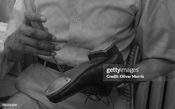 American tap dancer and actor Charles 'Honi' Coles tunes his tap shoes prior to a performance at the St. James Theater, New York, New York, 1984.