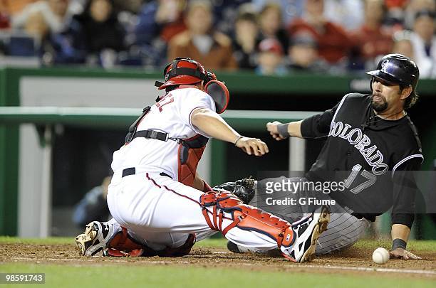 Todd Helton of the Colorado Rockies slides safely into home plate ahead of the tag of Ivan Rodriguez of the Washington Nationals April 19, 2010 at...