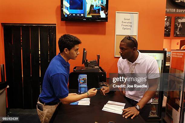 Eddie Sellos , who was recently hired by Best Buy, helps customer Mark Tinker as he shops at the Best Buy store on April 21, 2010 in Miami, Florida....