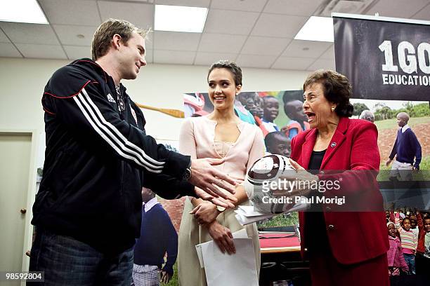 United soccer player Bryan Namoff presents Representative Nita Lowey with a soccer ball alongside actress Jessica Alba at a news conference to...