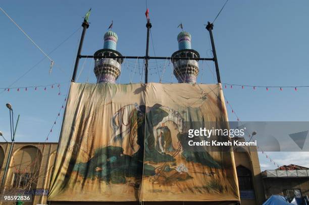Huge banner with depiction of Battle of Ashura painted on it, is displayed outside a mosque with its erect minarets seen in the background on The Day...