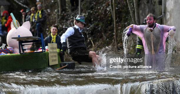 Maximilian Neudeck and Christoph Sieber under the Zuber motto 'Landesgartenschau' stand in the Schiltach during the Da-Bach-na-Fahrt in Schramberg,...