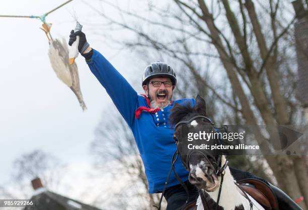 The day's winner of the traditional geese riding of the Geese Rider Club Sevinghausen, Joerg Wendorf, celebrates with the head of the wooden goose in...