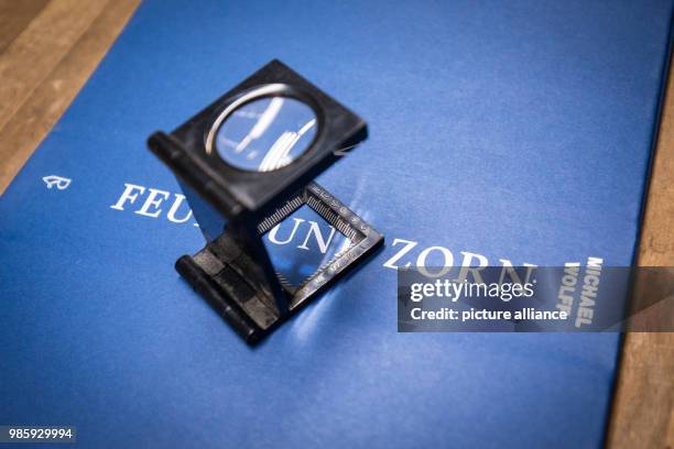 Linen tester stands on a freshly printed and glued cover of the book 'Feuer und Zorn. Im Weissen Haus von Donald Trump', the German first issue of...