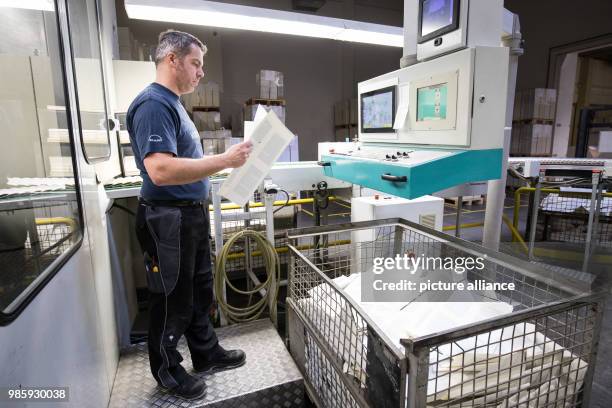 Lars Erichson, printer and machine operator, checks freshly printed text sheets of the book 'Feuer und Zorn. Im Weissen Haus von Donald Trump', the...