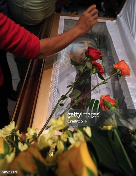 Woman poses a rose on the coffin of television journalist and university professor Jorge Alberto Orellana during his funeral held in San Pedro Sula,...