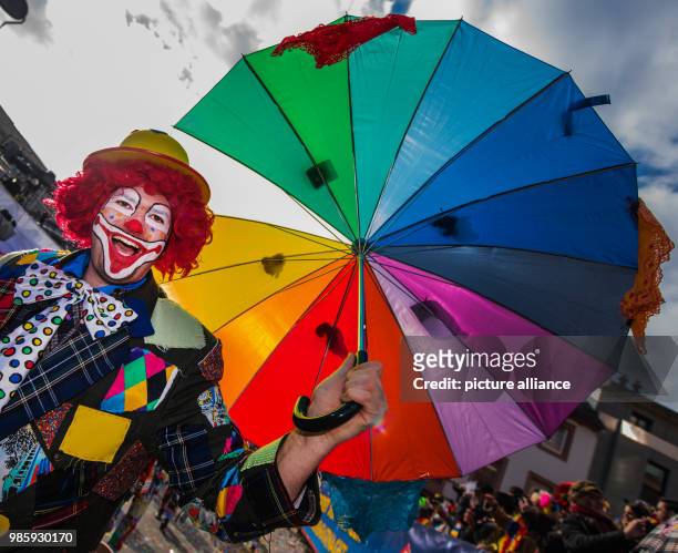 Jester of the 'Schwarze Gesellen Mainz-Laubenheim' with an umbrella takes part in the Rosenmontag carnival procession in Mainz, Germany, 12 Febraury...