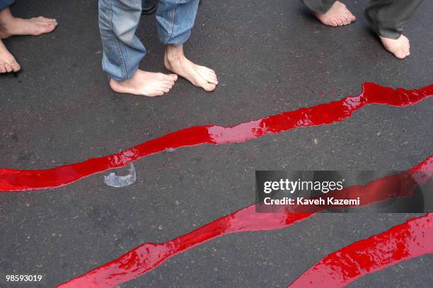 Barefeet men stand around while blood of a sacrificed lamb flows on the asphalt outside a mosque, in south Tehran, on The Day of Ashura in south...