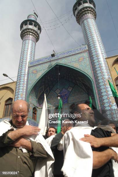 Men wearing white cloth and mud on their faces mourn outside Karbala-e ha mosque on The Day of Ashura in south Tehran. Ashura Day is on the 10th day...