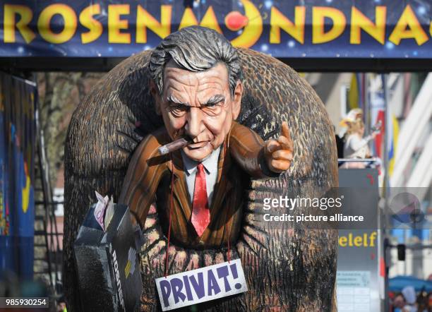 Political caricature float with a figure of former German Chancellor and board member of the Russian oil company Rosneft, G. Schroeder, holding a...