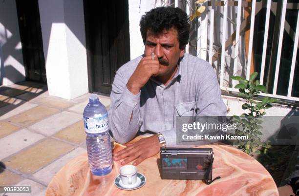 Muhammad Zaydan or better known as Abu Abbas listens to news of 1991 Gulf War, while smoking a cigarrette, while in his residence courtyard in...