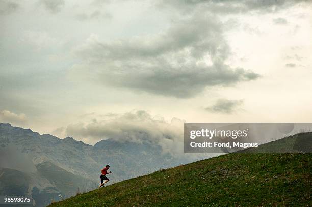 a man jogging in the mountains, italy. - uphill stock pictures, royalty-free photos & images