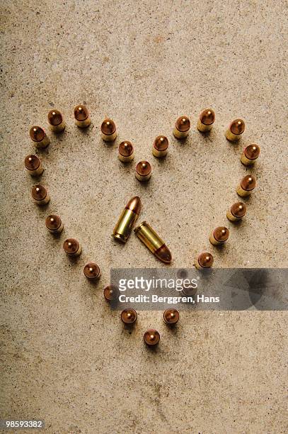 ammunition on the floor formed into a heart. - cartridge stock pictures, royalty-free photos & images