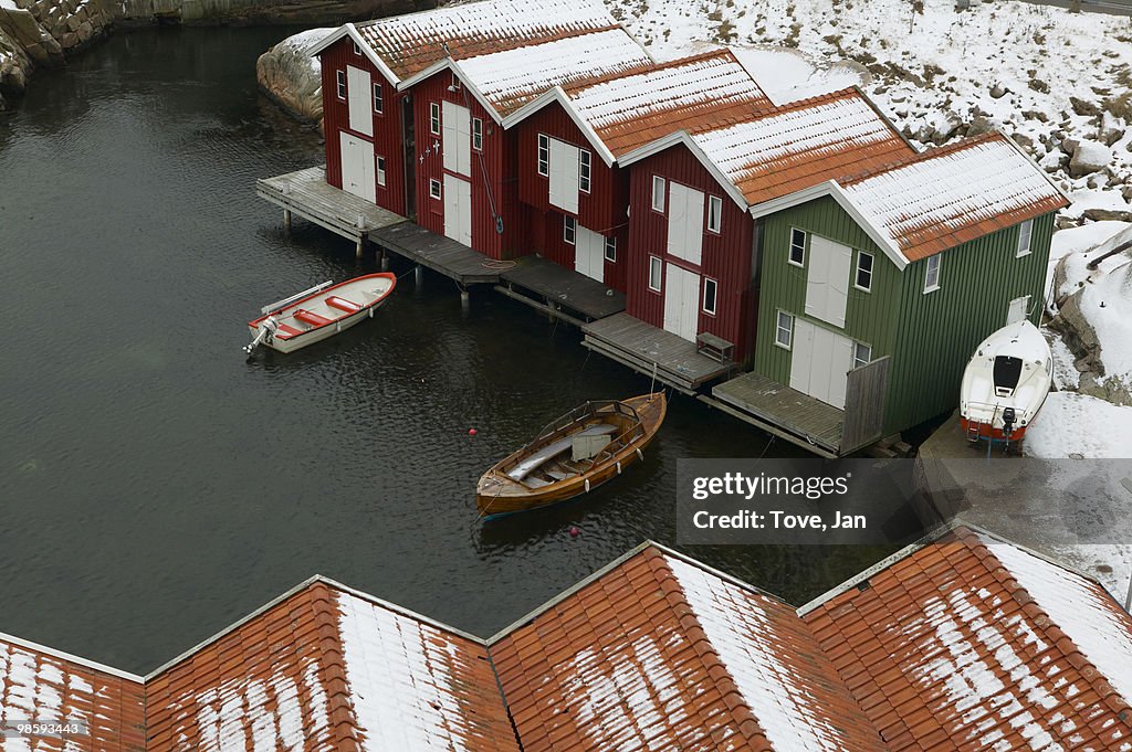 Boathouses with snowy roofs, Sweden.