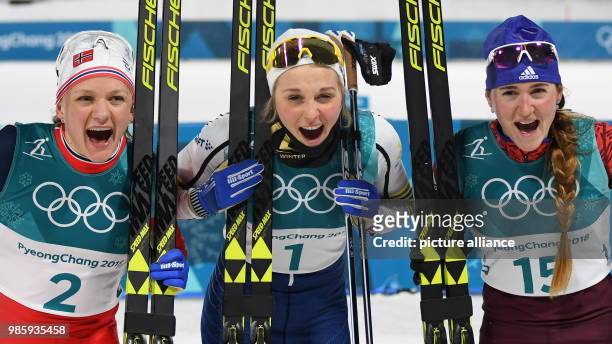 Maaiken Caspersen Falla from Norway, Stina Nilsson from Sweden and Julia Belorukova from the Russian team celebrate their performances at the women's...