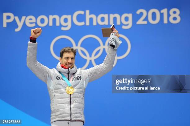 German gold medallist Arnd Peiffer celebrates on the podium during the medal ceremony of the men's 10km biathlon sprint on day four of the...
