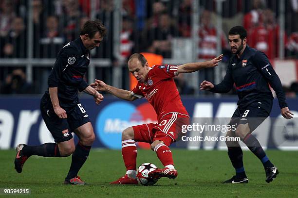 Arjen Robben of Bayern is challenged by Kim Kaellstroem and Lisandro of Lyon during the UEFA Champions League semi final first leg match between FC...