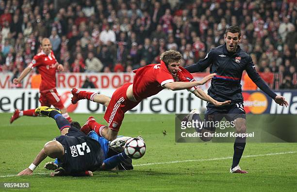 Thomas Mueller of Bayern is challenged by Cris and goalkeeper Hugo Lloris of Lyon during the UEFA Champions League semi final first leg match between...
