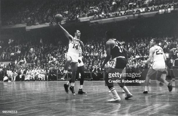 Bob Cousy of the Boston Celtics shoots a hook shot against Elgin Baylor of the Los Angeles Lakers as Frank Ramsey looks on during a game in the...