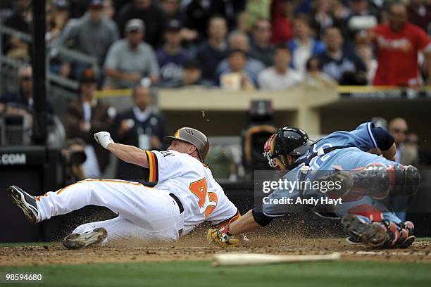 Matt Stairs of the San Diego Padres slides home by catcher Brian McCann of the Atlanta Braves on Jackie Robinson Throwback Thursday at Petco Park on...