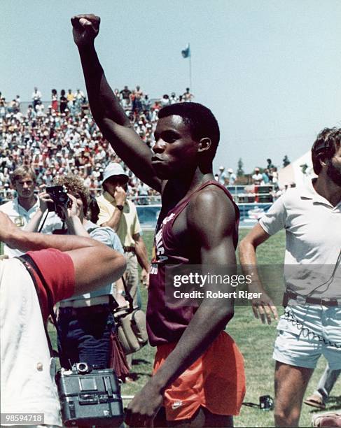 Carl Lewis raises his right fist, circa 1980s.