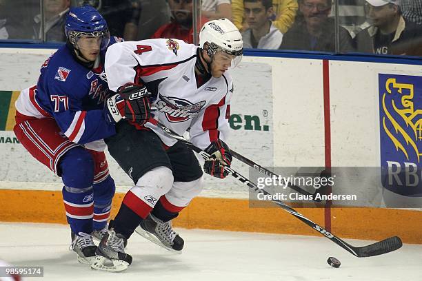 Taylor Hall of the Windsor Spitfires skates with the puck while being checked by Jonathan Jasper of the Kitchener Rangers in Game Four of the Western...