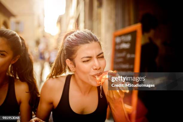 essen pizza  - woman eating pizza stock-fotos und bilder