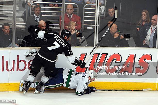 Rob Scuderi of the Los Angeles Kings throws a check against Alexandre Burrows of the Vancouver Canucks in Game Three of the Western Conference...