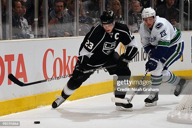 Dustin Brown of the Los Angeles Kings skates with the puck against Alexander Edler of the Vancouver Canucks in Game Three of the Western Conference...