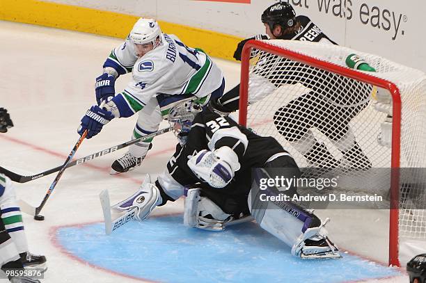 Alexandre Burrows of the Vancouver Canucks skates with the puck against Matt Greene and Jonathan Quick of the Los Angeles Kings in Game Three of the...