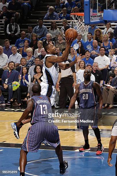 Rashard Lewis of the Orlando Magic shoots a layup against Nazr Mohammed and Raymond Felton of the Charlotte Bobcats in Game One of the Eastern...