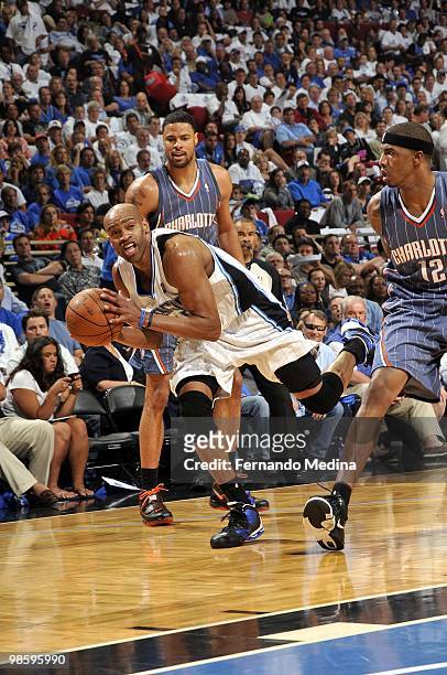 Vince Carter of the Orlando Magic looks to make a play against Tyson Chandler and Tyrus Thomas of the Charlotte Bobcats in Game One of the Eastern...