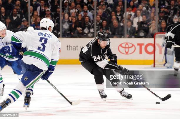 Alexander Frolov of the Los Angeles Kings skates with the puck against Kevin Bieksa of the Vancouver Canucks in Game Three of the Western Conference...