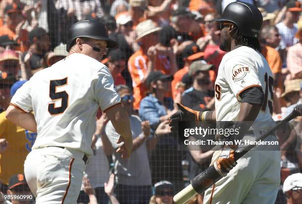 Nick Hundley of the San Francisco Giants is congratulated by Alen Hanson aftr Hundley scored against the San Diego Padres in the bottom of the...