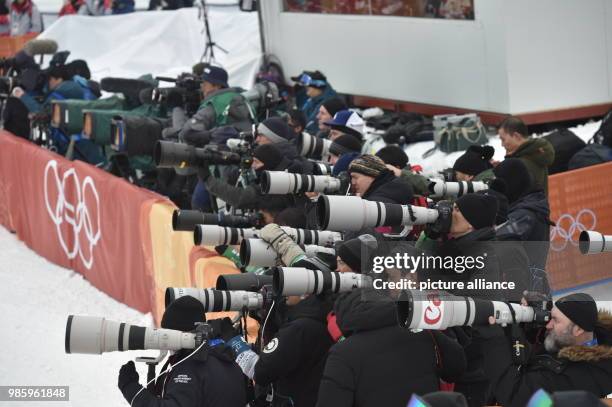 Numerous photographers standing behind a banner during the men's halfpipe event's final of the 2018 Winter Olympics in the Bokwang Snow Phoenix Park...