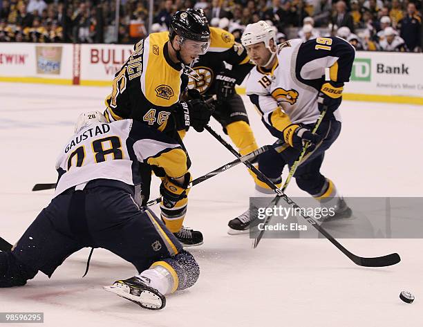 David Krejci of the Boston Bruins tries to keep the puck as Paul Gaustad of the Buffalo Sabres defends in Game Four of the Eastern Conference...