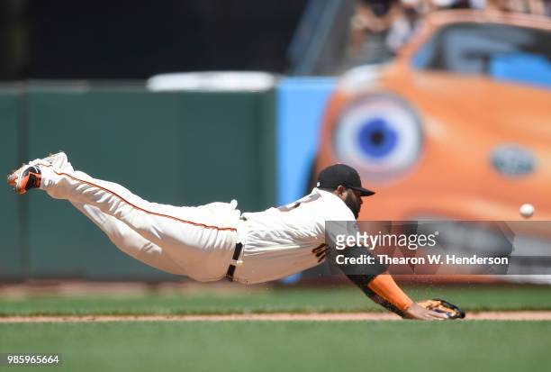 Pablo Sandoval of the San Francisco Giants dives for this ball that goes for a base hit off the bat of A.J. Ellis of the San Diego Padres in the top...