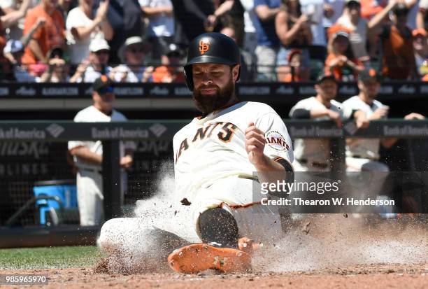 Brandon Belt of the San Francisco Giants scores against the San Diego Padres in the bottom of the six inning at AT&T Park on June 23, 2018 in San...