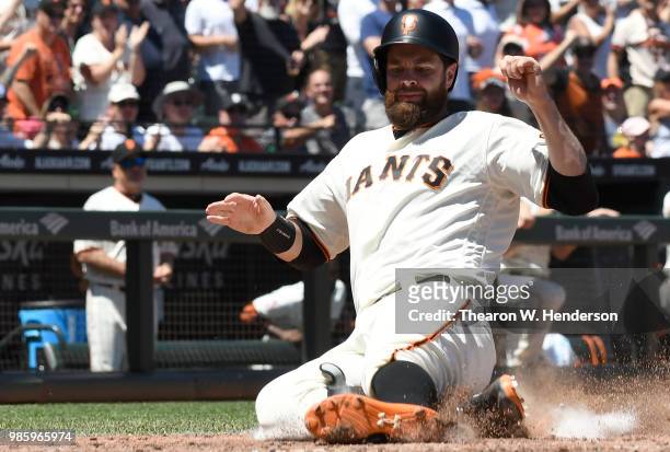 Brandon Belt of the San Francisco Giants scores against the San Diego Padres in the bottom of the six inning at AT&T Park on June 23, 2018 in San...