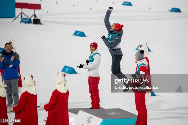 Winner Eric Frenzel from Germany celebrating with second-placed Akito Watabe from Japan and third-placed Lukas Klapfer from Austria after his victory...