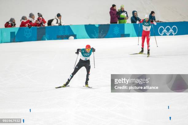 Eric Frenzel from Germany approaching the finish line ahead of Akito Watabe from Japan during the Nordic combined event in the Alpensia Ski Jump...