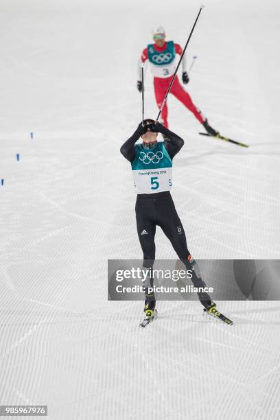 Eric Frenzel from Germany approaching the finish line ahead of Akito Watabe from Japan during the Nordic combined event in the Alpensia Ski Jump...