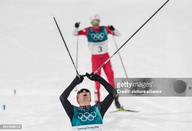 Eric Frenzel from Germany approaching the finish line ahead of Akito Watabe from Japan during the Nordic combined event in the Alpensia Ski Jump...