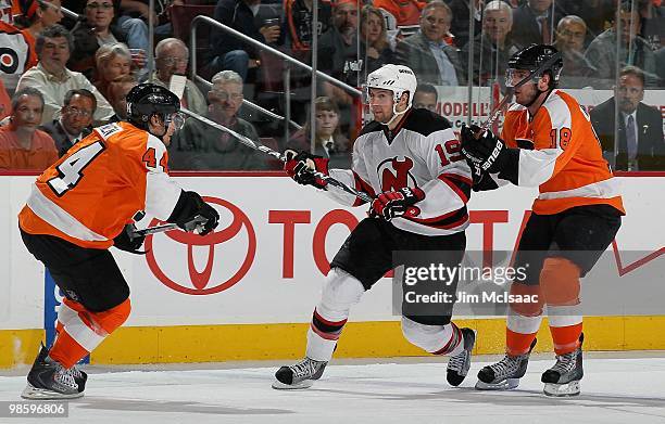 Travis Zajac of the New Jersey Devils skates against Kimmo Timonen and Mike Richards of the Philadelphia Flyers in Game Four of the Eastern...