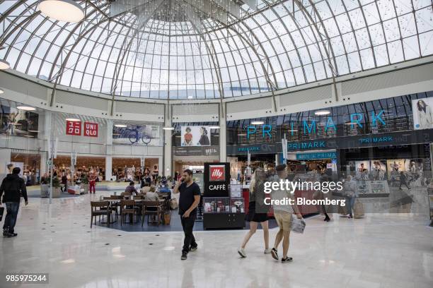 Uniqlo store, operated by Fast Retailing Co., left, and a Primark fashion store, operated by Associated British Foods Plc, stand beyond a food court...