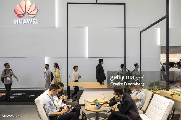 Attendees use laptop computers while sitting at the Huawei Technologies Co. Booth at the Mobile World Congress Shanghai in Shanghai, China, on...