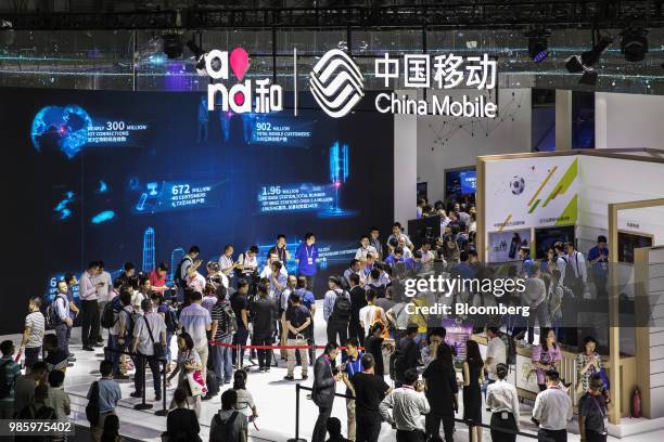 Attendees stand at the China Mobile Ltd. Booth at the Mobile World Congress Shanghai in Shanghai, China, on Thursday, June 28, 2018. The exhibition...